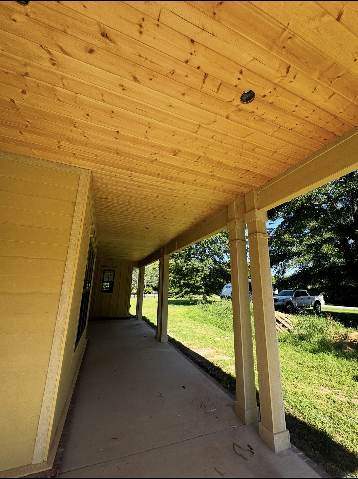 Long covered porch with pine tongue-and-groove ceiling and Hardie-wrapped columns in Fayetteville